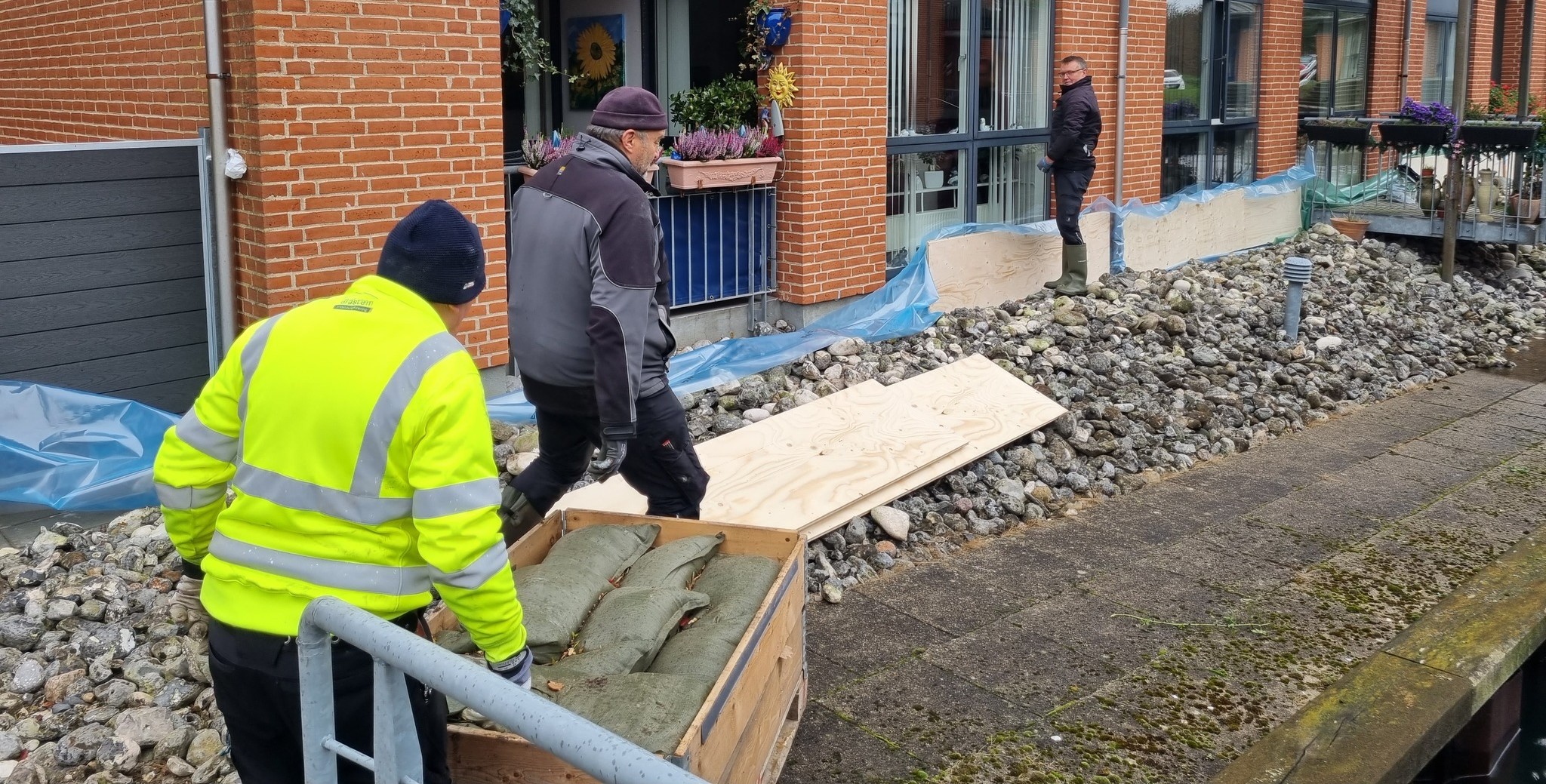 Sandsække, Plader Og Presseninger Bliver Sat Op For At Beskytte Almene Boliger I Gråsten Mod Stormflod I Oktober 2023. Foto SALUS