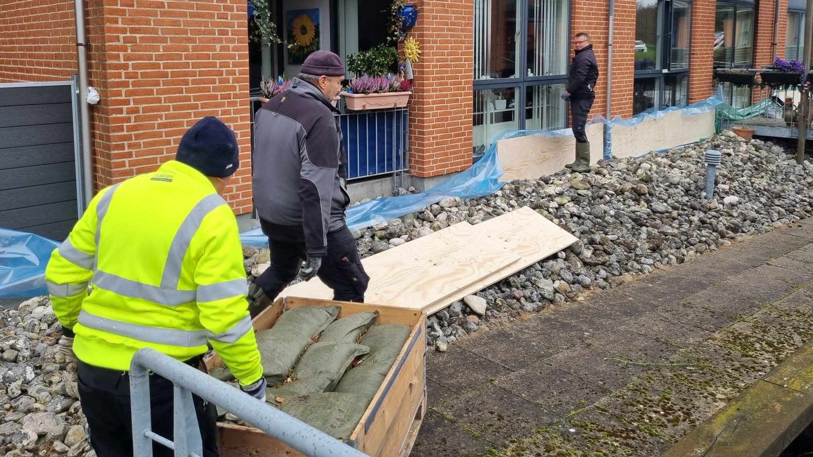 Sandsække, Plader Og Presseninger Bliver Sat Op For At Beskytte Almene Boliger I Gråsten Mod Stormflod I Oktober 2023. Foto SALUS
